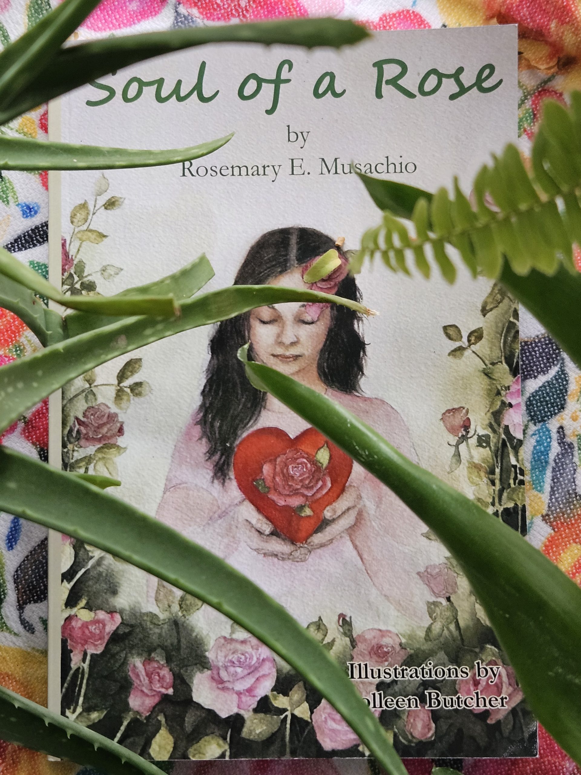 Soul of a Rose a book of poetry by Rosemare E. Musachio seen through plat leaves.